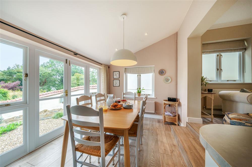 The dining area with beautiful views from the french doors  at Fig and Bay Cottage, Axminster