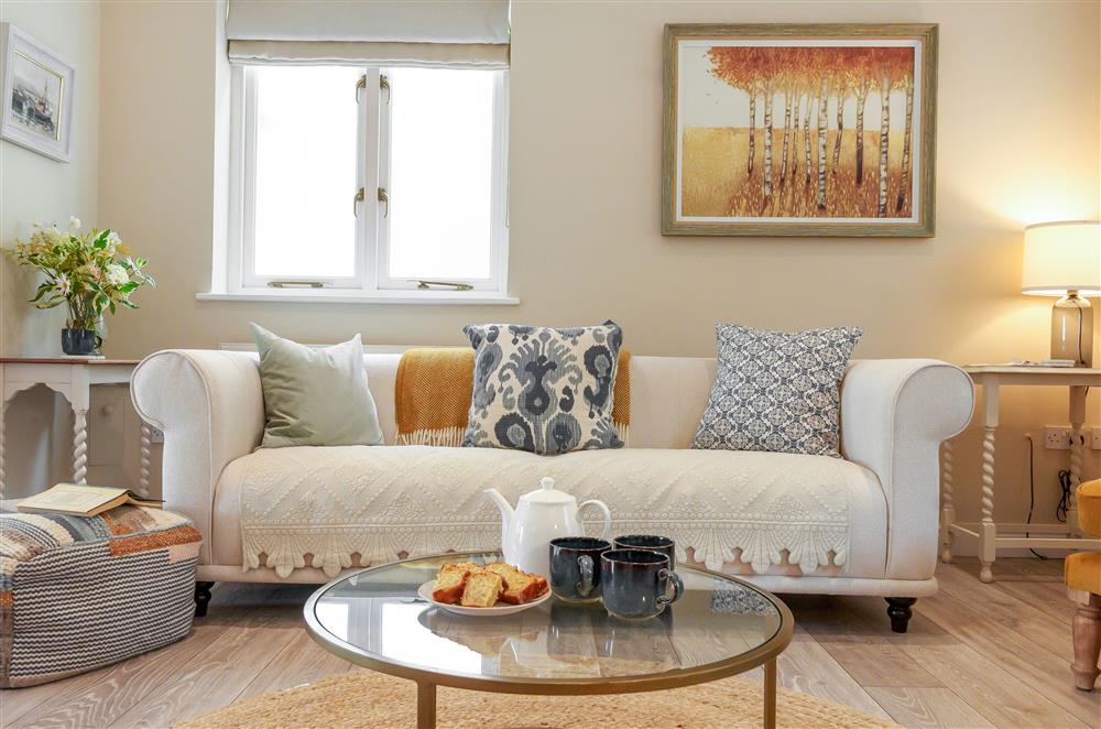 The stylish sitting area with large sofa and armchairs at Fig and Bay Cottage, Axminster