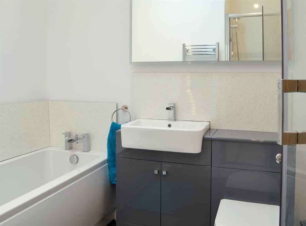 En-suite bathroom with bath and shower cubicle at Fig Tree Cottage in Pancrasweek, near Bude, Cornwall