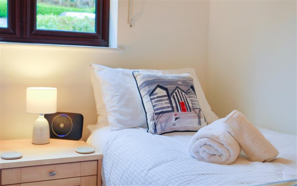 The beach hut cushions look great against the white bed covers. at Finders, 87 Keeper's Cottage in Maenporth