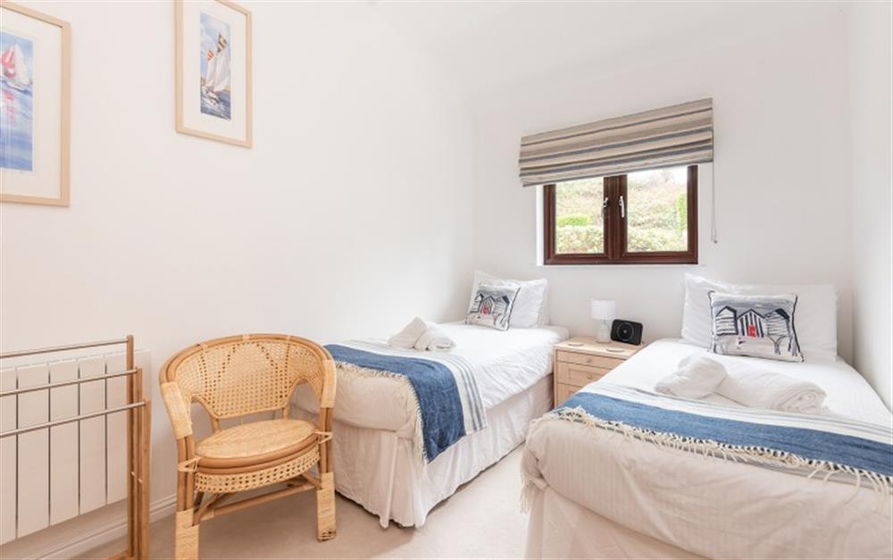 The throws and cushions in the twin bedroom give the neutral tones a pop of colour at Finders, 87 Keeper's Cottage in Maenporth