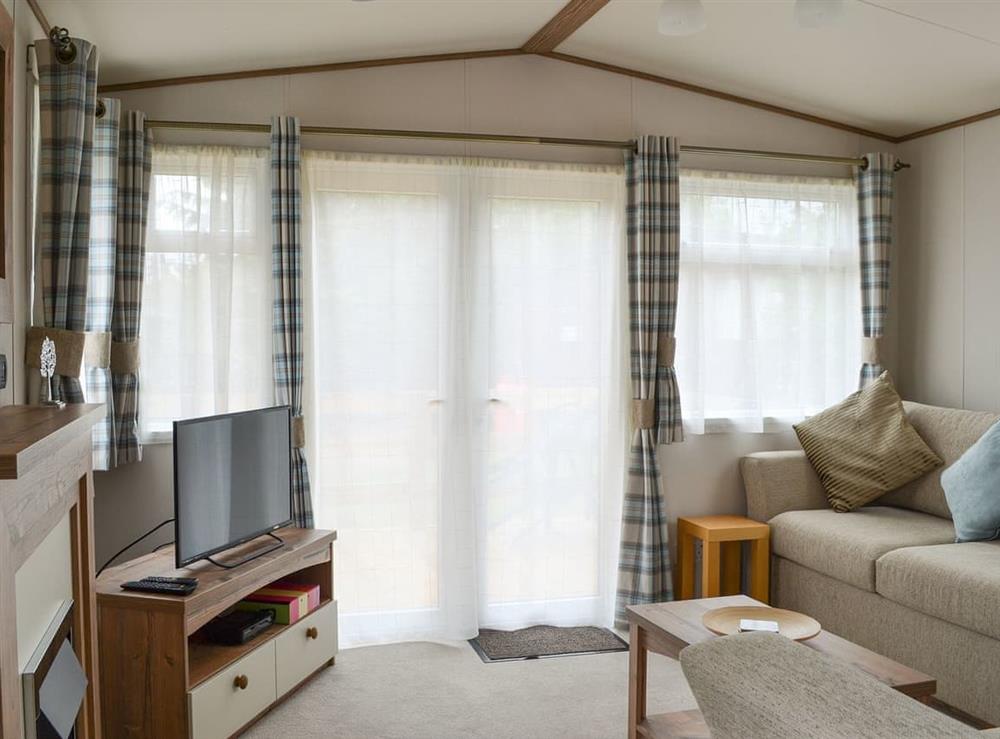 Comfortable lounge area with TV at Fir Tree Lodge in Aviemore, Highlands, Inverness-Shire