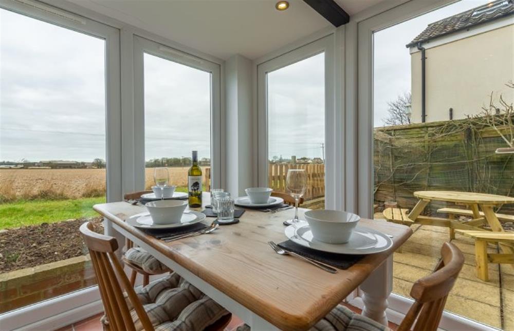 Ground floor: Dining conservatory with table and seating for four and open countryside views at First and Last, Trimingham near Norwich