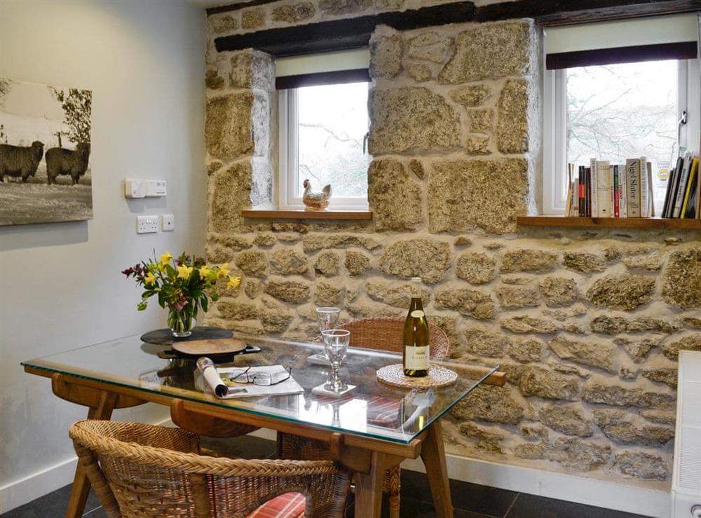 Dining area with exposed stone feature wall at Fishermans Nook in Dartmeet, near Yelverton, Devon, England