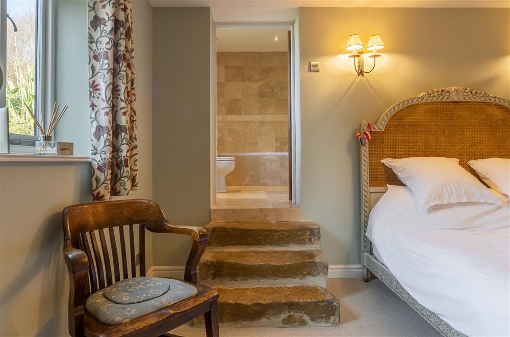 Master bedroom and steps leading to en-suite bathroom at Five Acres, Boltby