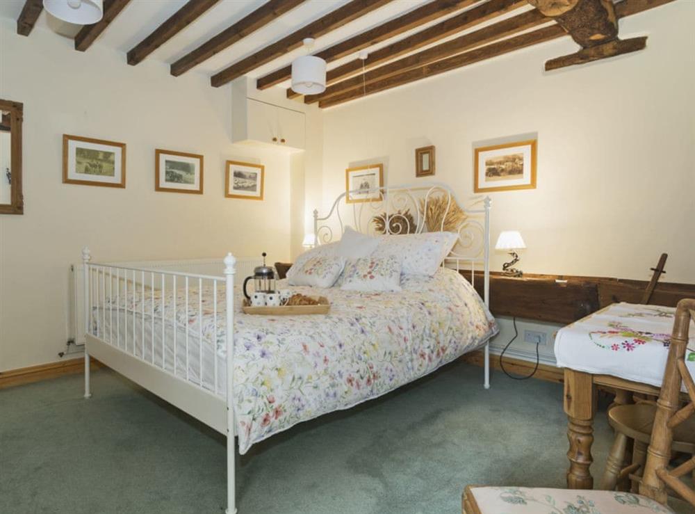 Elegantly decorated double bedroom with en-suite bathroom at Flowers Barn in Middle Duntisbourne, near Cirencester, Gloucestershire
