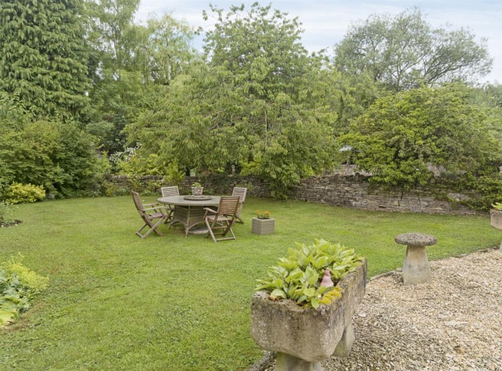 Peaceful garden with sitting-out area at Flowers Barn in Middle Duntisbourne, near Cirencester, Gloucestershire