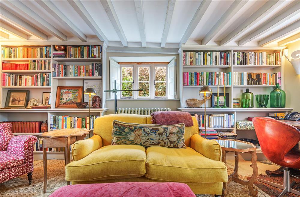 Comfortable seating and well-stocked bookshelves for relaxing  in the sitting room at Ford Cottage, Corscombe