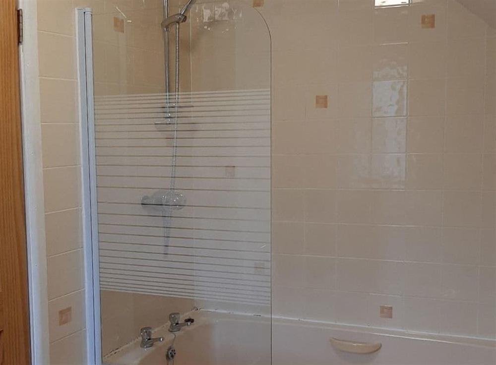 Bathroom with shower over the bath at Forge Cottage in Shaldon, Devon