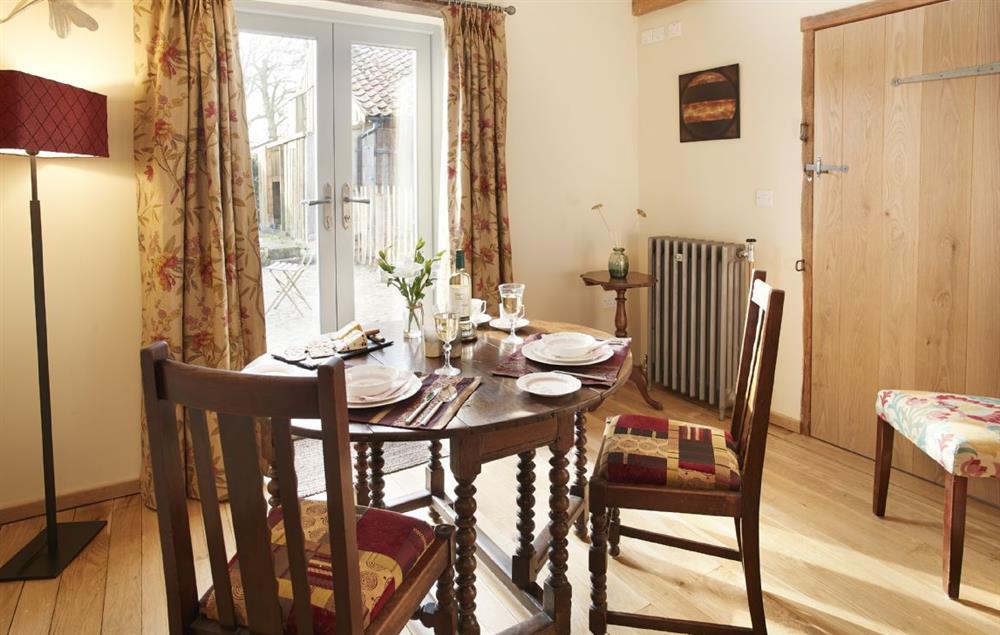 Dining area with french windows opening on to the courtyard garden at Forge Croft, Skirpenbeck 