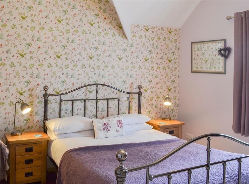 Double bedroom with antique style bed at Forge Villa in Ebberston, near Pickering, North Yorkshire