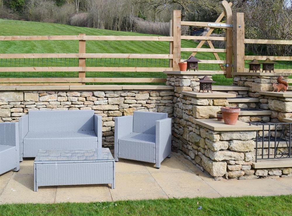 Seating area within the garden and steps and gated access to adjoining paddock at Forge Villa in Ebberston, near Pickering, North Yorkshire