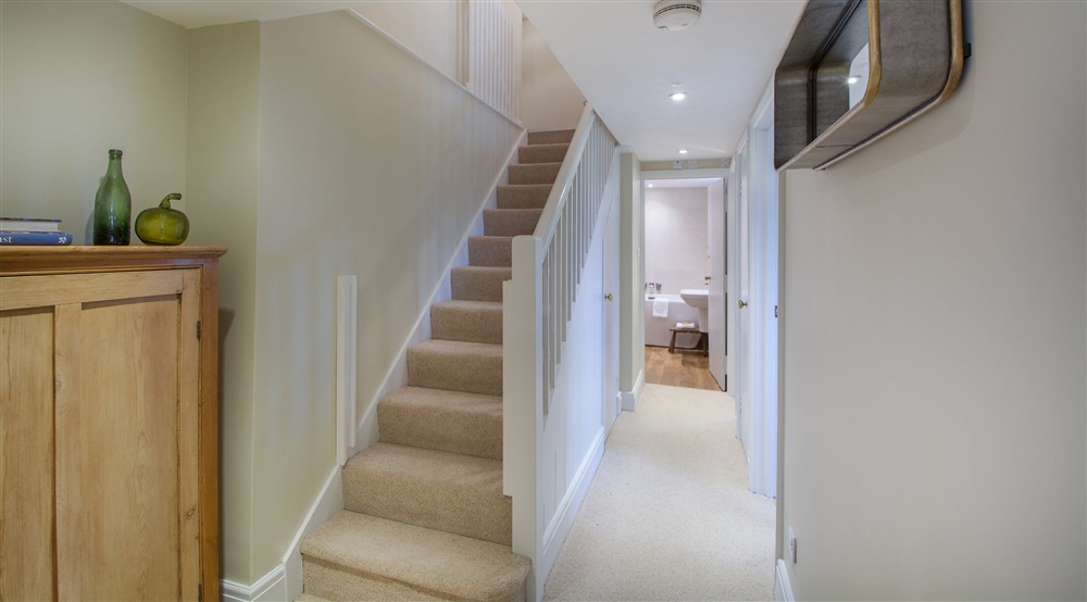The staircase leads downstairs to the bedrooms and bathroom at Fortescue in Lanteglos-by-fowey, Cornwall