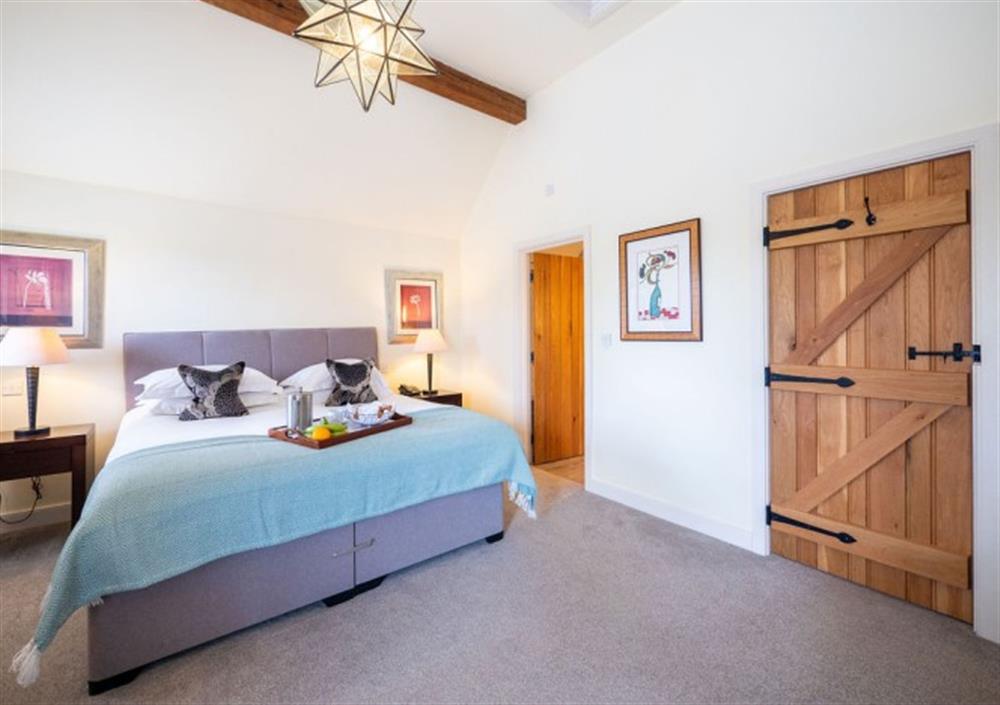 Bedroom 1 with high ceilings and door to ensuite at Fox Tor in Chagford