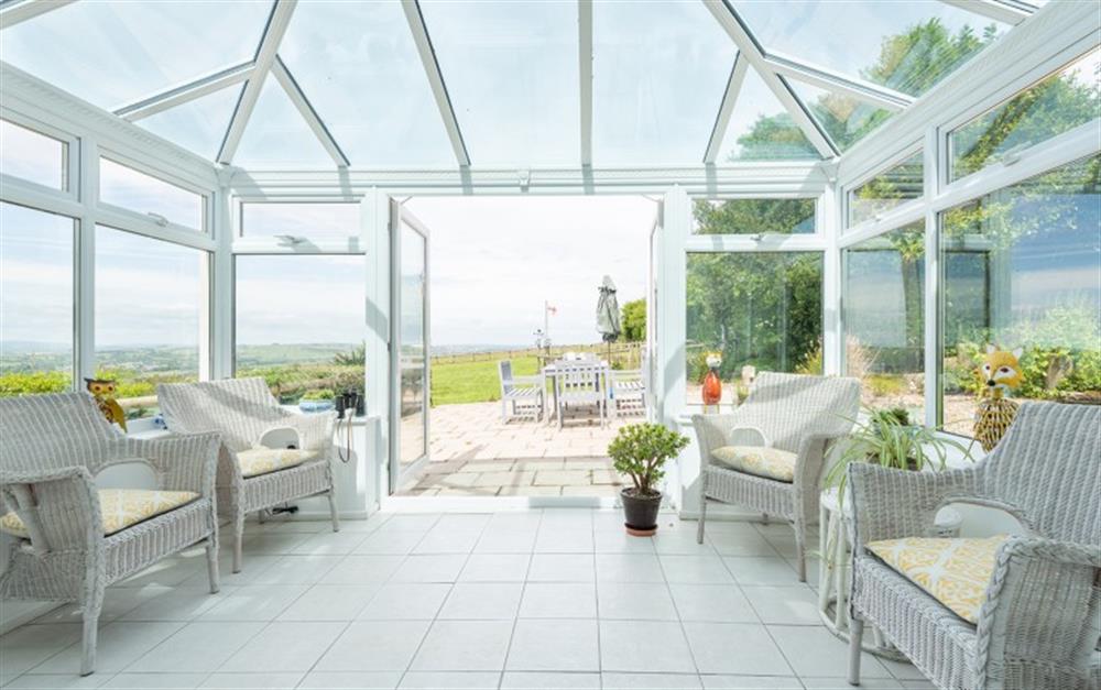 The lovely sunny conservatory with views over the garden and beyond. at Foxenhole Farmhouse in Dittisham