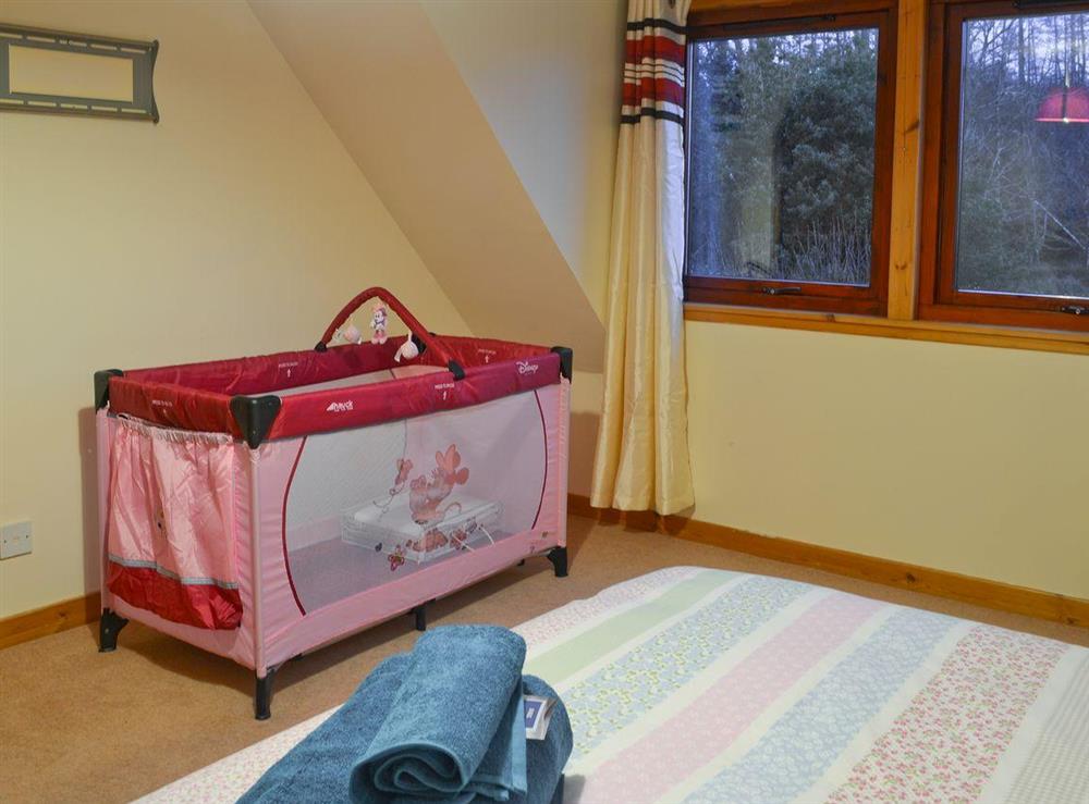 double bedroom with childs cot at Foxhole Farm Cottage in Beauly, Inverness-Shire