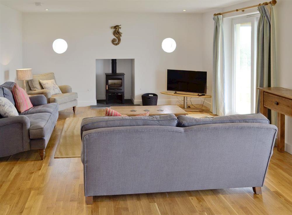Spacious living and dining room with wood burning stove at Freefolk in Polzeath, Cornwall