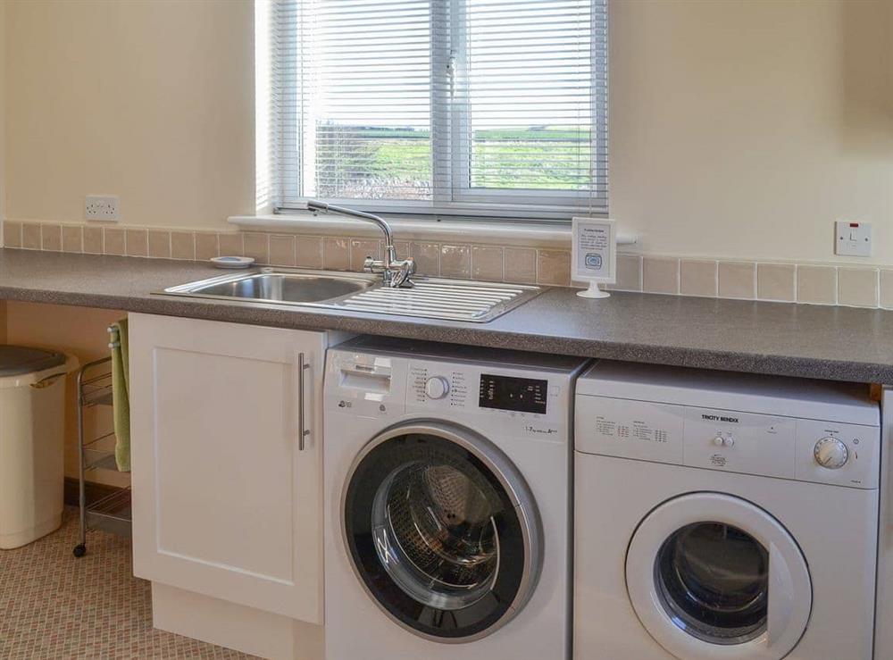 Practical utility room with laundry facilities at Friarystone Cottage in Bamburgh, Northumberland., Great Britain