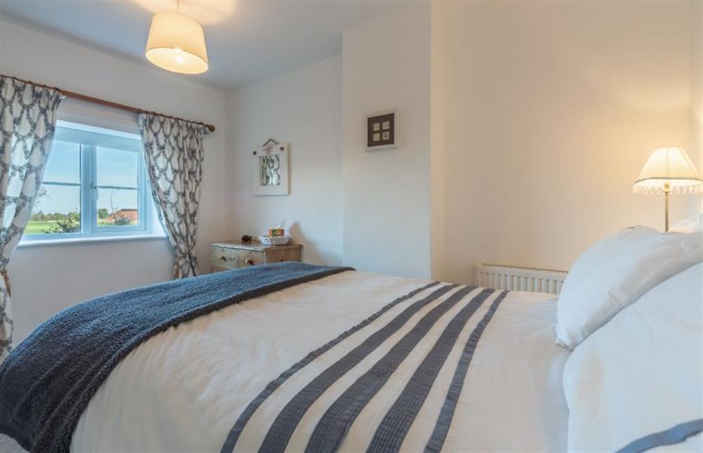 First floor: Bedroom two with views across the marshes at Froggy Cottage, Thornham near Hunstanton