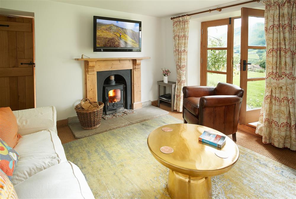 Ground floor: Sitting room with cosy wood burning stove and french doors leading out to the garden at Fron Cottage, Llangynog, Oswestry