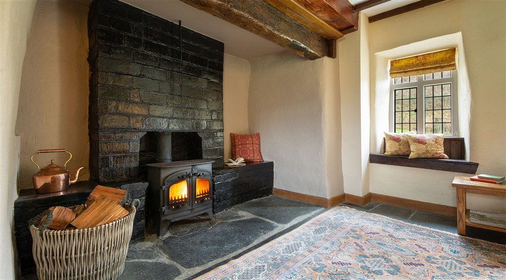 The inglenook fireplace with woodburner in the sitting room of Fron Dirion, Powys at Fron Dirion in Dinas Mawddwy, Powys