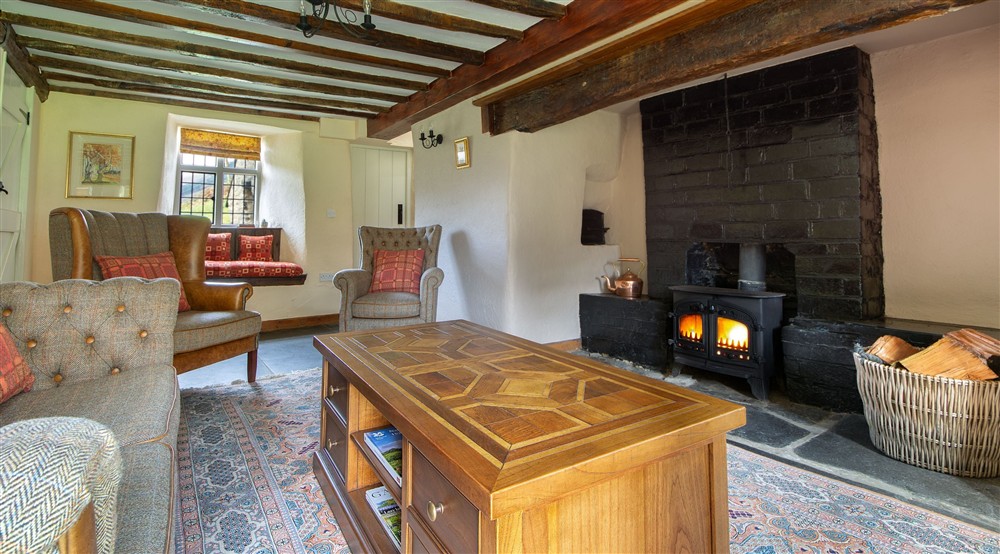 The sitting room with woodburner and window seats at Fron Dirion in Dinas Mawddwy, Powys