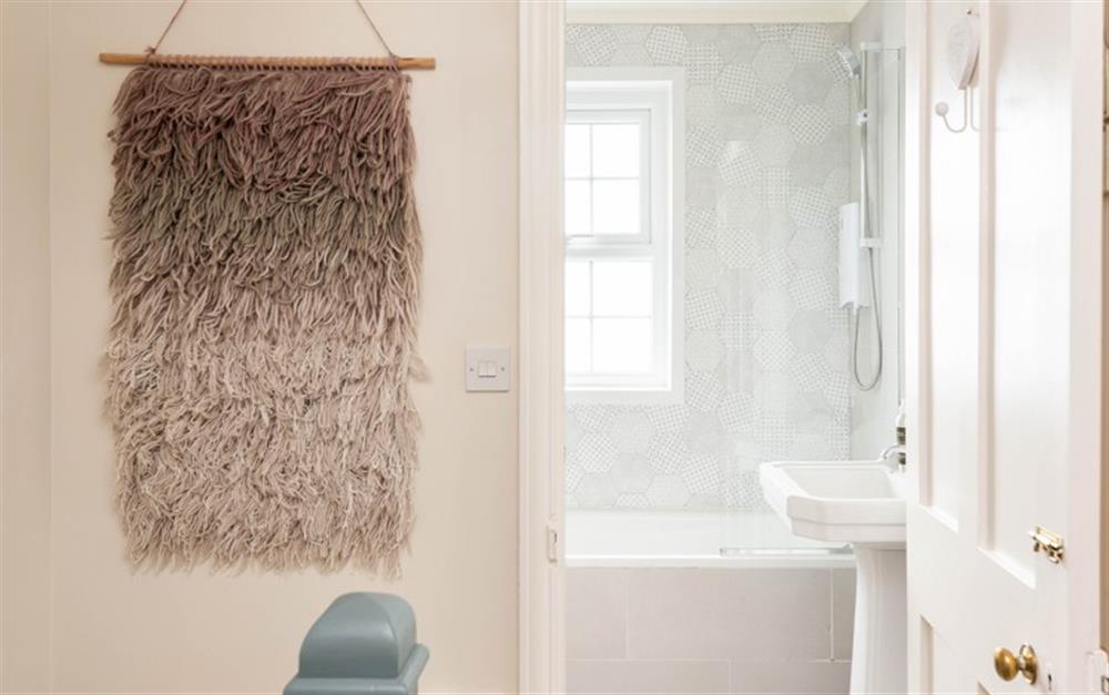 The family bathroom consisting of bath with shower over, basin and WC at Fuchsia Cottage in Salcombe