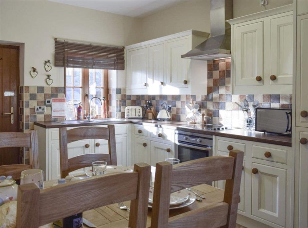 Well-equipped kitchen with dining area at Beudy Bach, 