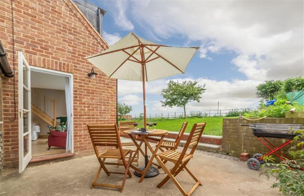 Rear garden with table and seating for four and barbecue at Gallery Cottage, Wighton near Wells-next-the-Sea