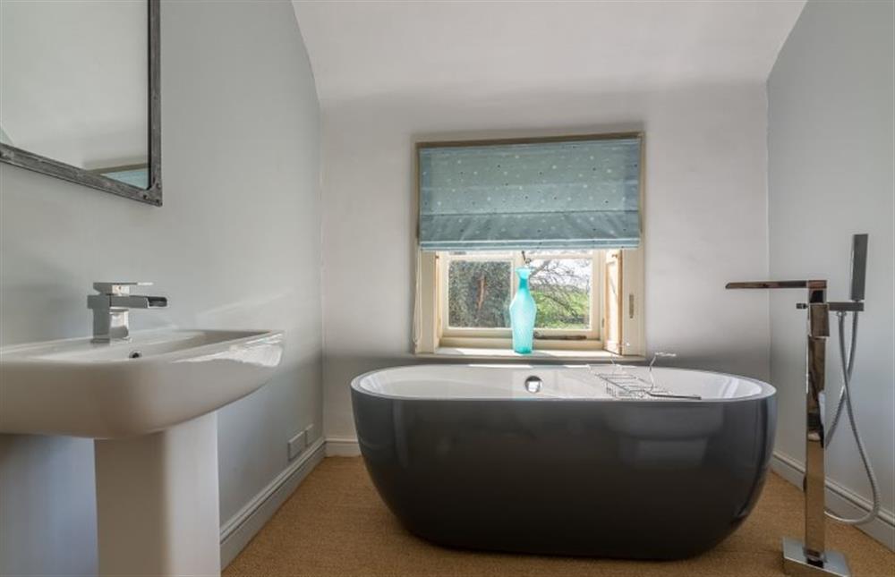 First floor:  Bathroom with contemporary roll top bath at Gamekeepers Lodge, South Raynham near Fakenham