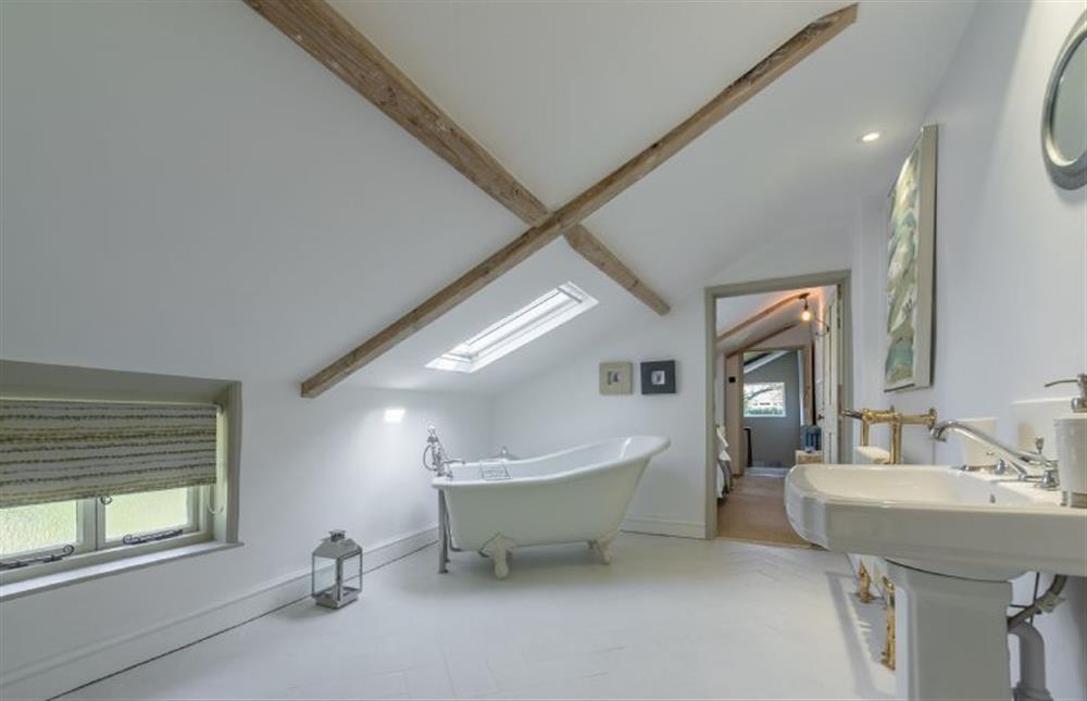 First floor:  En-suite bathroom with traditional roll top bath with hand held shower at Gamekeepers Lodge, South Raynham near Fakenham