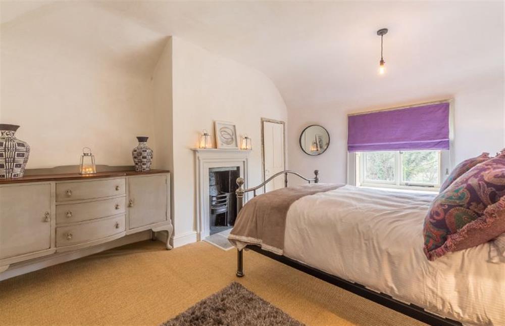 First floor:  Master bedroom with king size bed and chest of drawers at Gamekeepers Lodge, South Raynham near Fakenham