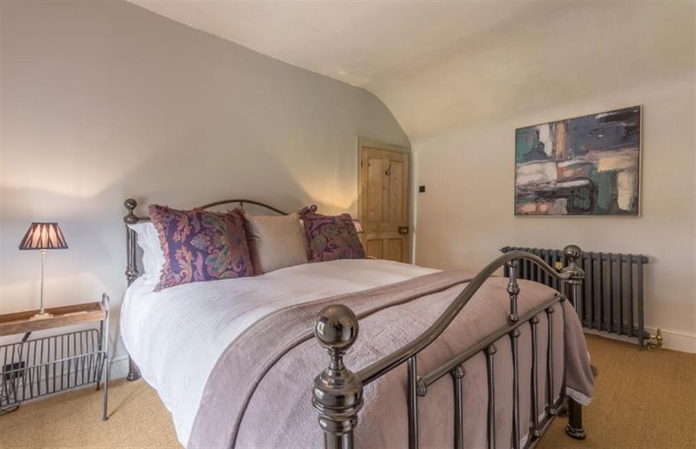 First floor:  Master bedroom with king size wrought iron bed at Gamekeepers Lodge, South Raynham near Fakenham