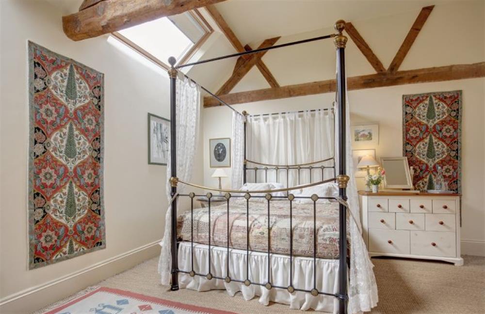 Ground floor:  Master bedroom with iron and brass four-poster bed at Garden Cottage, Manor House Farm, Wellingham near Kings Lynn