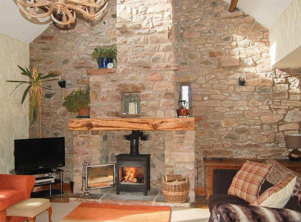 Imposing living room with open fireplace and wood burner at Garden Cottage in Pooley Bridge, Ullswater, Cumbria