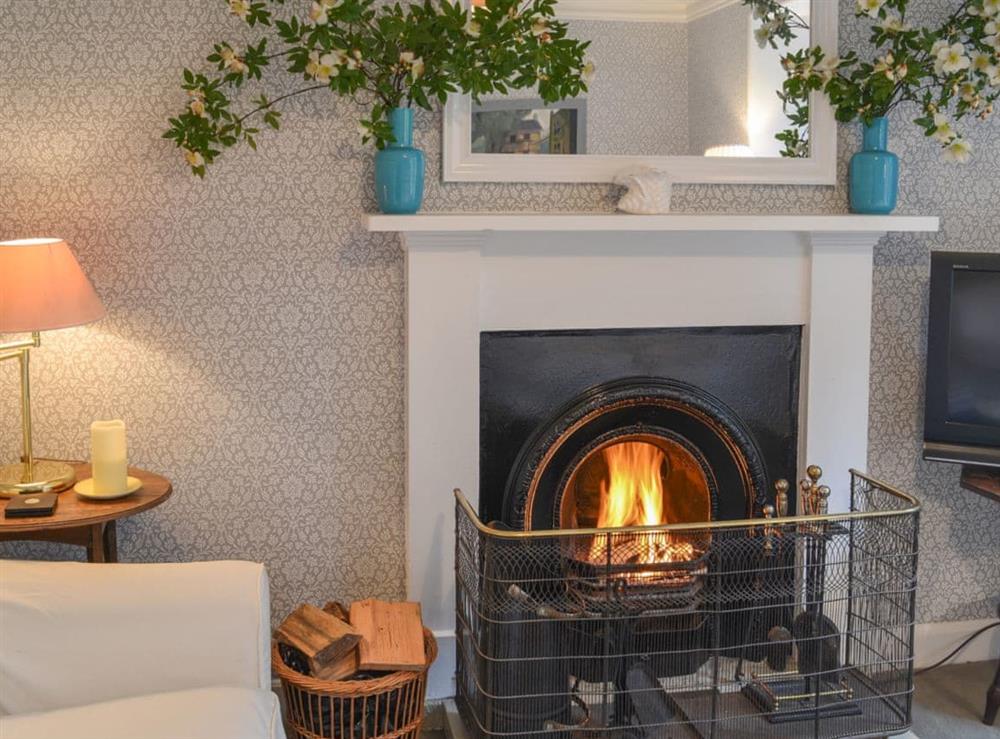 Warm and welcoming living room with open fireplace at Garden Cottage in Strachur, near Dunoon, Argyll and Bute, Scotland