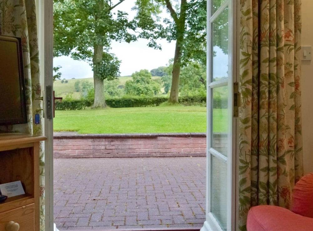 View through French doors from living room to patio and garden at Garden Farm Cottage in Ilam, Nr Ashbourne, Derbyshire., Staffordshire