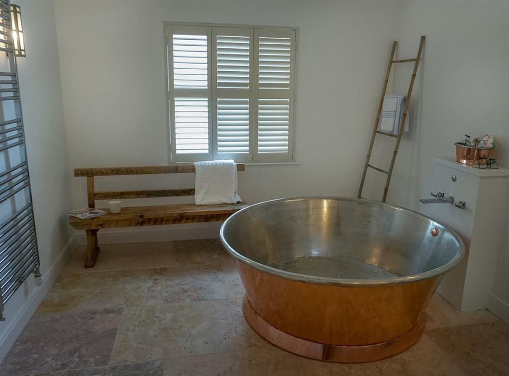 Luxurious bathroom with circular, copper bath at Garden House in Thimbleby, near Northallerton, North Yorkshire