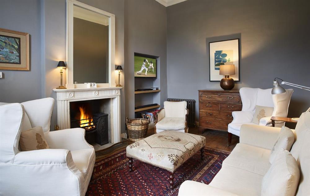 Cosy sitting room with open fire at Garden House, Wolterton