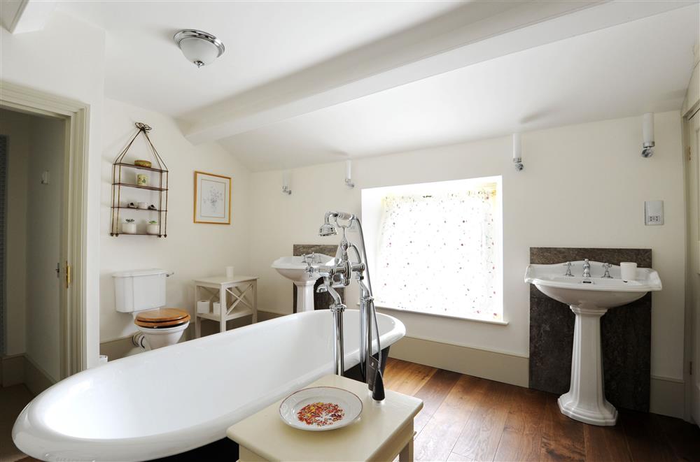 Bedroom three’s en-suite bathroom with roll-top bath and walk-in shower at Gardeners Cottage, Chatsworth Estate, Edensor, Nr Bakewell