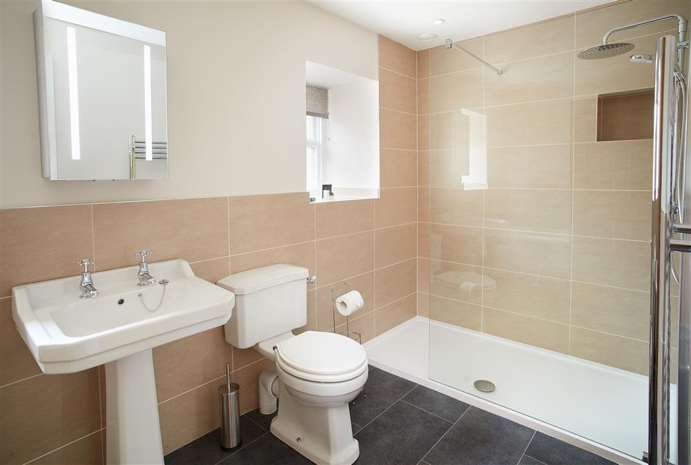 Bathroom with walk-in shower and separate roll top bath at Gardeners Cottage, Netherby Hall, Longtown