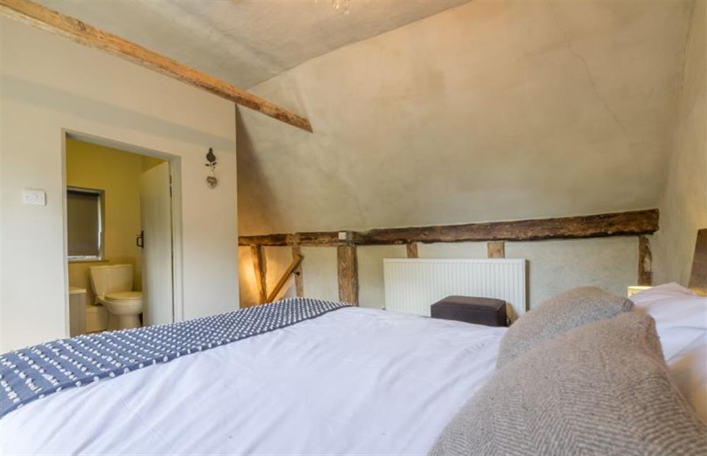 First floor: King size bedroom with feature beams and door to en suite at Gardeners Cottage, Thornham Magna near Eye