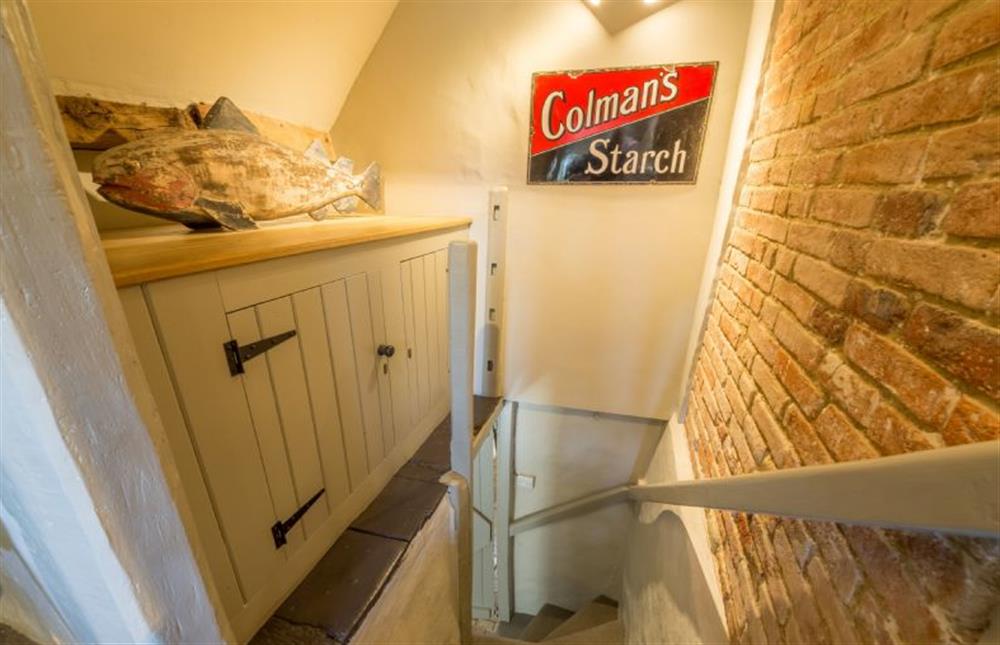 One of two steep, narrow staircases with exposed brick wall at Gardeners Cottage, Thornham Magna near Eye