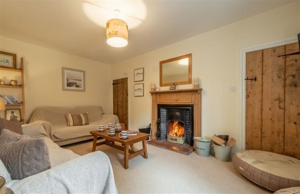 Cosy sitting room with an open fire at Gardeners Cottage, Thornham near Hunstanton