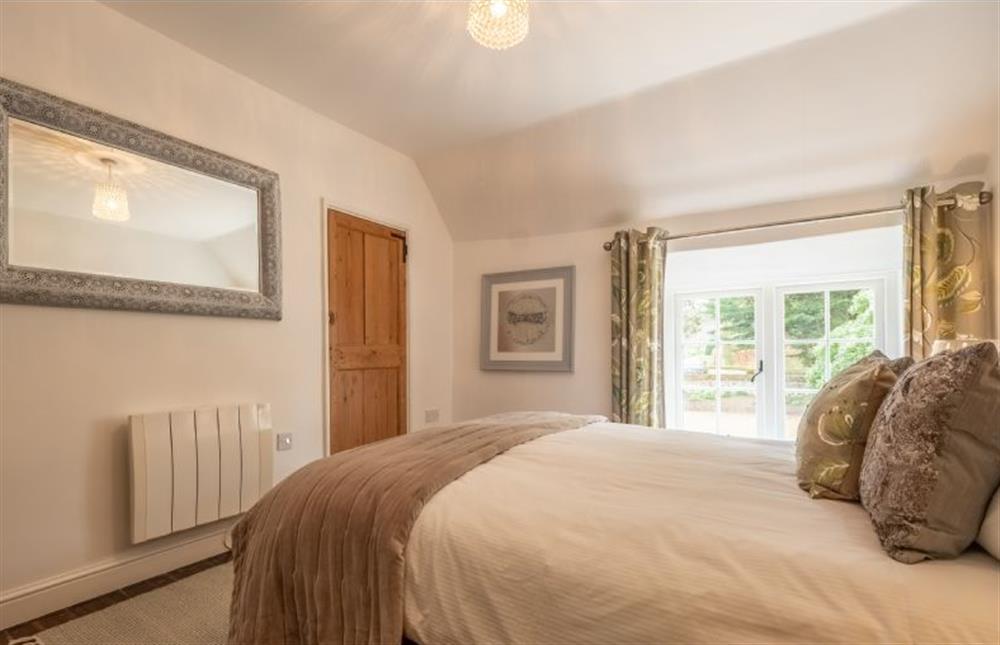 Master bedroom with a king-sized bed at Gardeners Cottage, Thornham near Hunstanton