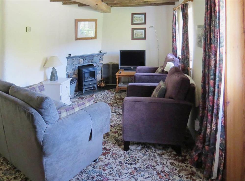 Beamed living room with feature fireplace at Garries Cottage in Keswick, Cumbria