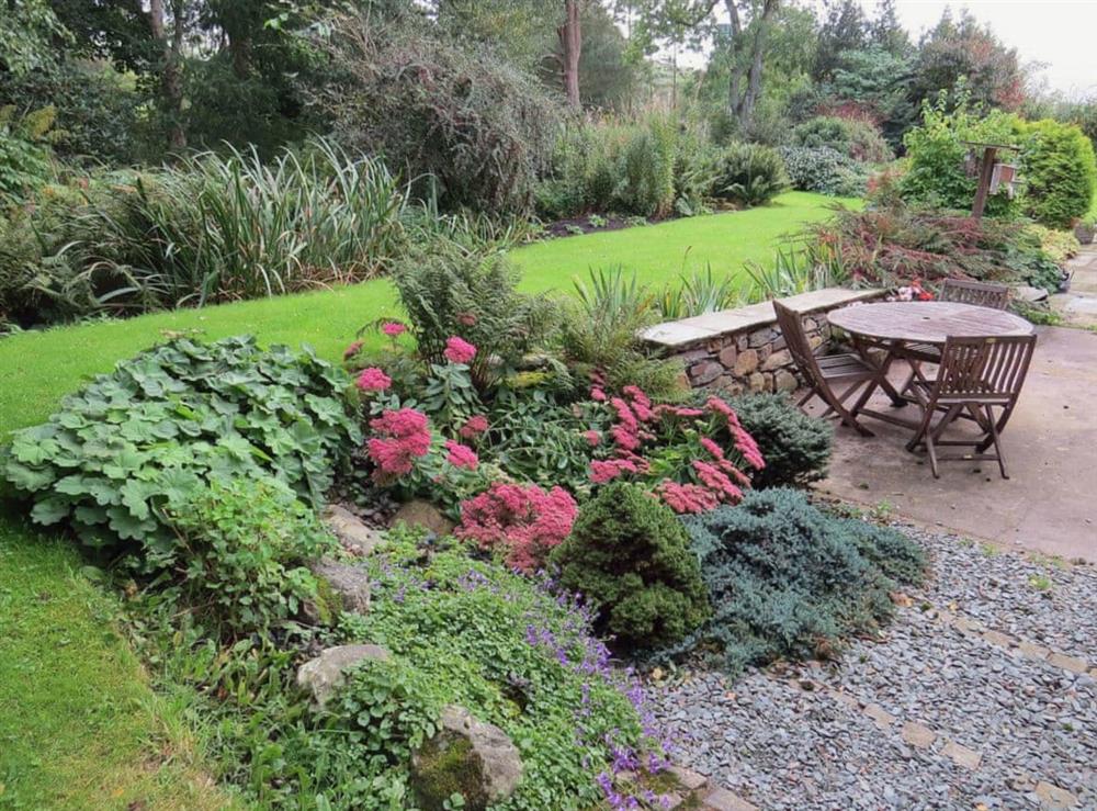 Well stocked garden with delightful table and chairs at Garries Cottage in Keswick, Cumbria