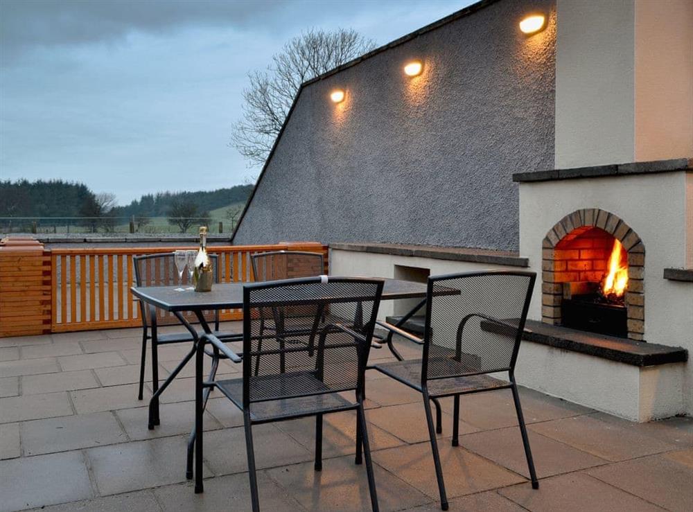 Sitting-out-area at dusk with cosy open fire (photo 2) at Blake Fell Lodge, 