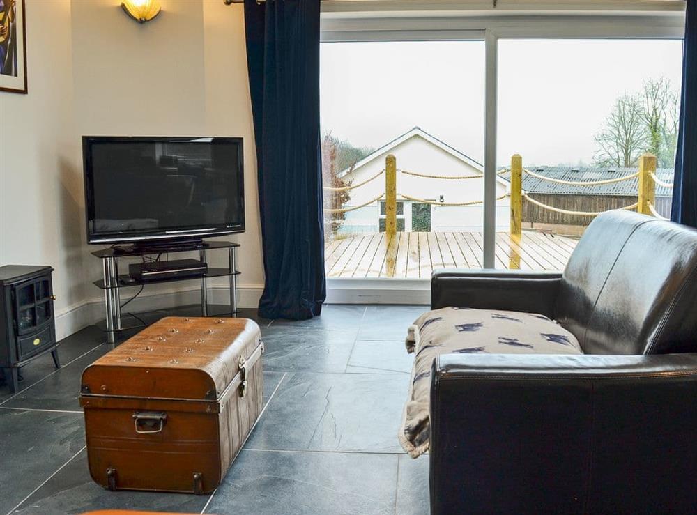 Inviting living area with patio doors leading to decking at Gatsby Getaway in Kentisbury, near Ilfracombe, Devon