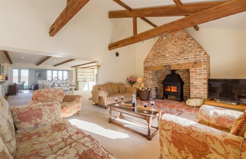 Ground floor: Sitting room has brick fireplace and wood burning stove at Geddings Farm Barn, Ringstead near Hunstanton